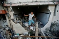 A Palestinian man inspects a house which police said was damaged in an Israeli air strike, in Gaza City