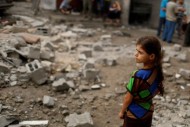 Palestinian girl looks at houses which witnesses said were damaged in an Israeli air strike that killed two children, in the northern Gaza Strip