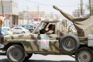 Shi'ite Houthi militants sit in a patrol vehicle, which is equipped with an anti-aircraft machine gun and was taken from the army recently, during a rally in Sanaa