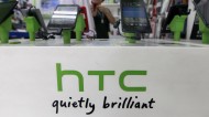 Customers look at HTC smartphones in a mobile phone shop in Taipei
