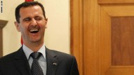 Syrian President Bashar al-Assad (L) lau