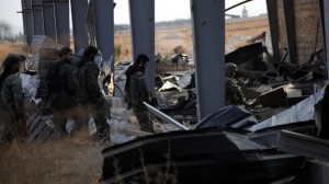 Forces loyal to Syria's President Bashar al-Assad walk in a damaged building in Base 80 area of Aleppo