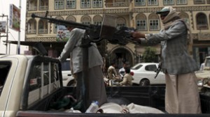 Followers of Yemen's al-Houthi Shi'ite group ride in an open vehicle while carrying weapons to secure a road in Saada