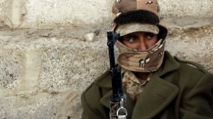An army soldier sits near a checkpoint on a street in Sanaa