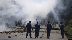 Policemen walk after they fire tear gas canisters at protesters during a protest against Burundi President Pierre Nkurunziza and his bid for a third term in Bujumbura