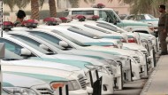 Saudi police cars are parked and policem