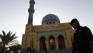 An Iraqi policeman stands guard outside a Sunni mosque during Eid al-Fitr prayers in Baghdad
