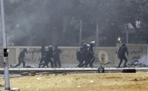 Riot police officers run during clashes with members of the Muslim Brotherhood and supporters of deposed Egyptian President Mohamed Mursi, at Rabaa Adawiya square, where they are camping, in Cairo