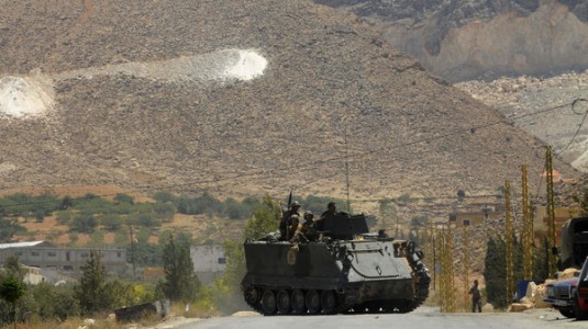 Lebanese army soldiers sit atop of armoured carrier at entrance of Sunni Muslim border town of Arsal, in eastern Bekaa Valley